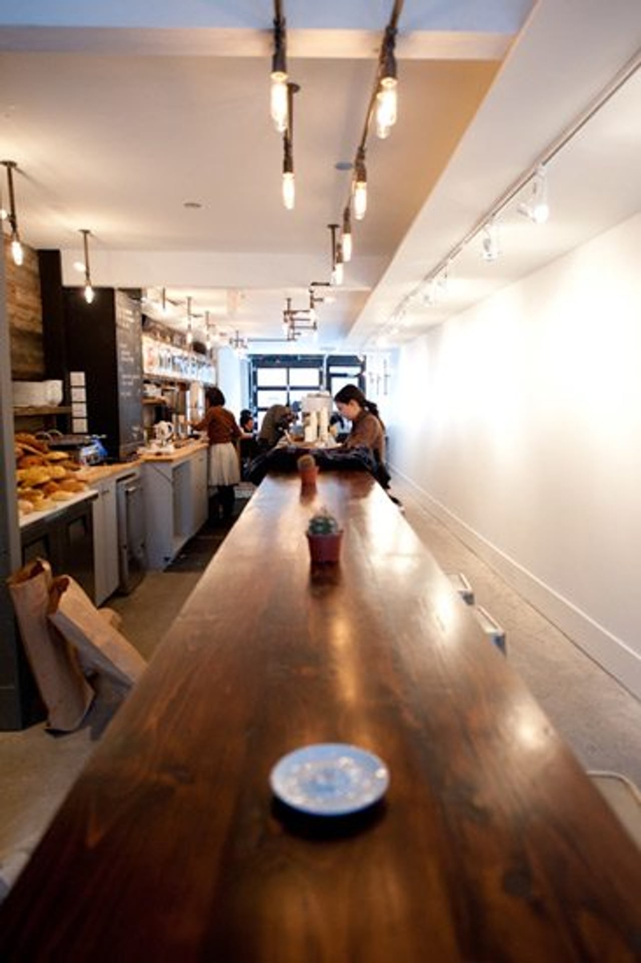 Café Pamenar — long wooden counter and pipe lighting
